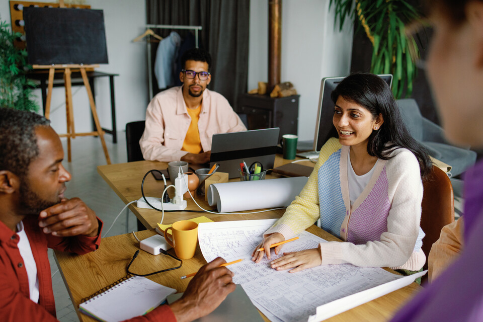 A diverse team collaborating around a table in a community workspace